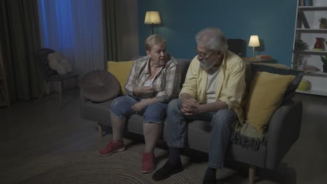 elderly couple arguing on sofa