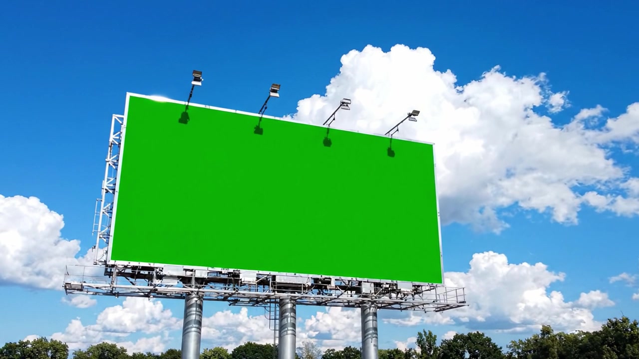 Et fantastisk grønt billboard mod en klar blå himmel med bløde hvide skyer, perfekt til reklame eller særlige budskaber, der indfanger essensen af essentielle udendørs medier.