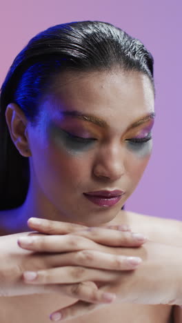 vertical video of biracial woman with black hair and make up, copy space, slow motion