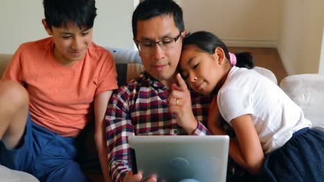 father and kids using digital tablet in living room 4k