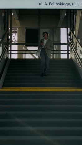 woman walking up stairs at a station