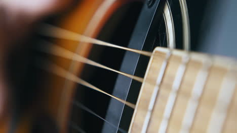 musician hand beats acoustic guitar body and nylon strings