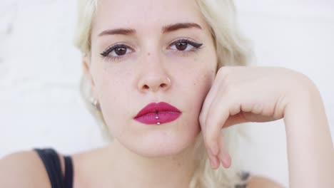 una joven rubia seria mirando fijamente a la cámara