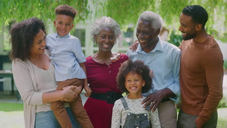 Portrait-Of-Smiling-Multi-Generation-Family-At-Home-In-Garden-Together