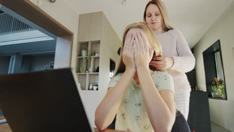 woman trying to untangle her teenage daughter's long hair