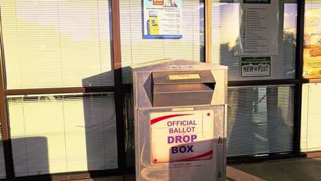 woman votes in election by casting mail-in ballot letter in slot at voting booth with offical ballot drop box sign for democratic government campaign in presidential race