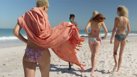 jonge volwassen vrienden lopen langs een strand 4k