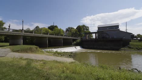 water mill next to bridge, jasper in water falls underneath