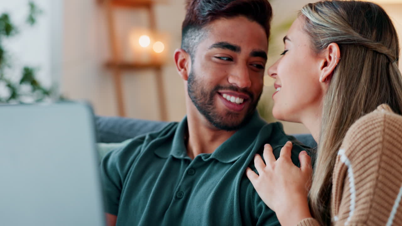 pareja feliz con computadora portátil en el sofá para bienes raíces