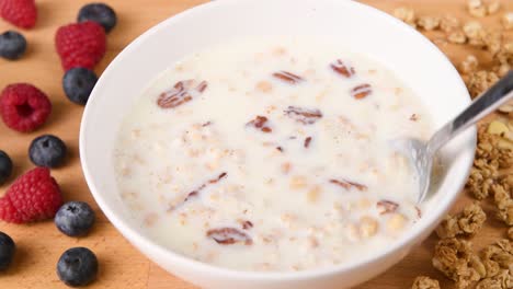 revolviendo un tazón de cereal con granola y fruta