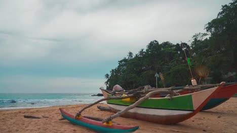 um belo circuito de vídeo sem costura de um barco de pesca tradicional de cauda longa em uma remota praia de areia tropical asiática no sri lanka com uma vibrante vista panorâmica do mar e céu nublado. água turquesa em um local de férias turístico cênico.