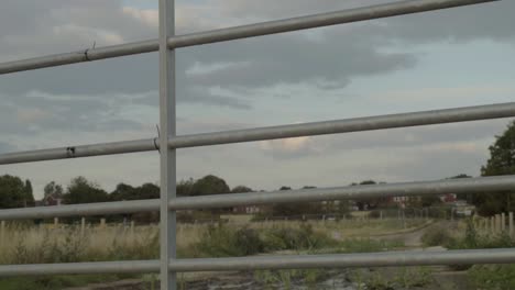 metal gate closing on farmland in rural countryside