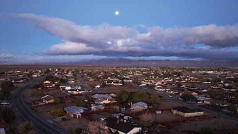 California-City-in-the-Mojave-Desert-basin-scenic-ascending-aerial-view-with-the-full-moon-above-the-clouds