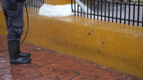 primer plano de la cintura para abajo de una persona lavando el pavimento en un parque