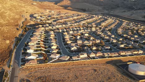 this ethereal drone shot gradually pushes into a sprawling neighborhood at sunset, capturing the warm, orange glow from a high altitude perspective