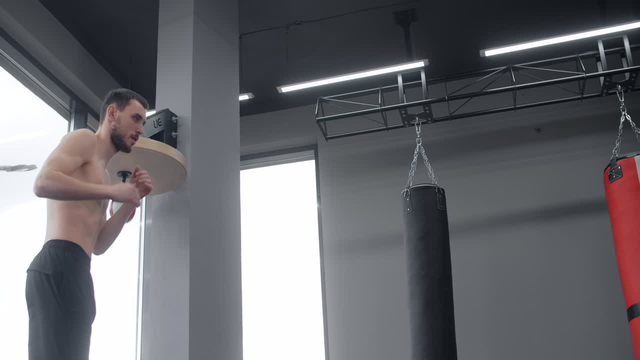 Man practicing kickboxing in a gym