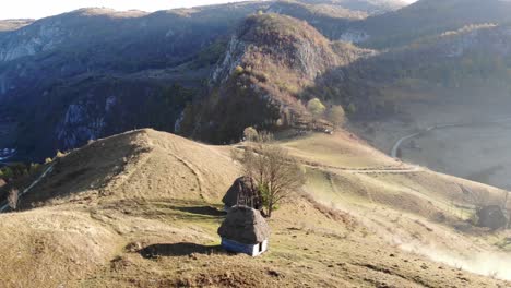 Epic-foggy-morning-in-a-remote-Romanian-village-with-thatched-roof-houses