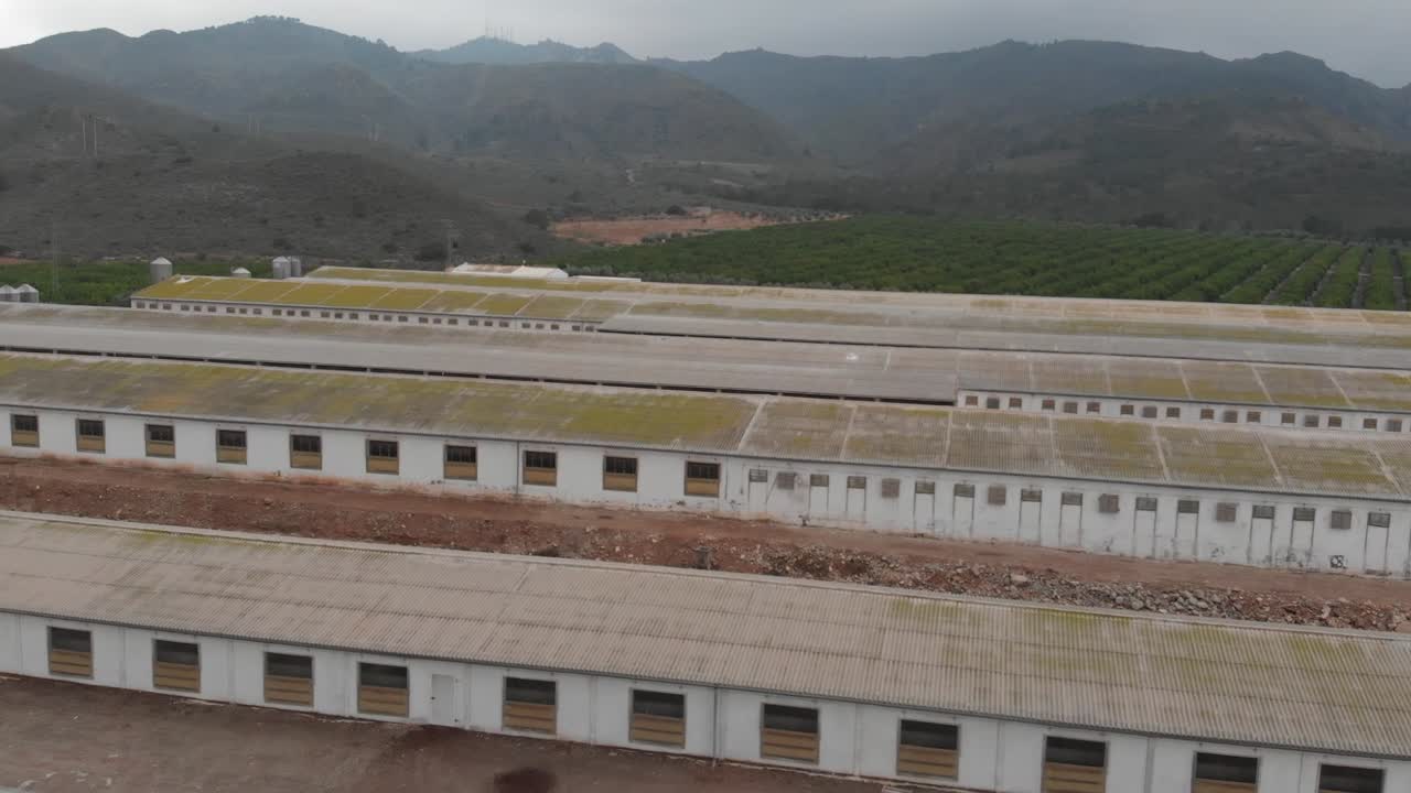 Large industrial farm buildings nestled in a mountain valley