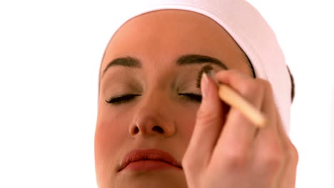 make up artist putting powder on models face