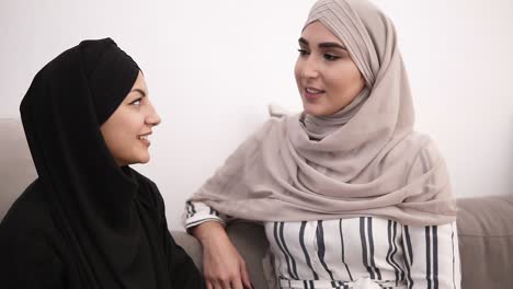 Two-Muslim-Woman-Sitting-On-Sofa-Relaxing-And-Talking