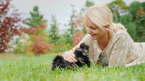 woman playing with two puppies