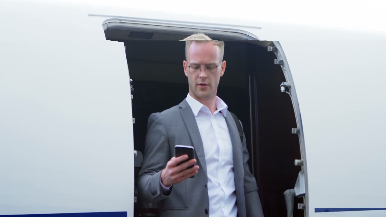 hombre de negocios hablando por teléfono móvil mientras se mueve fuera de un jet privado 4k