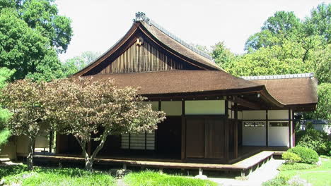A traditional Japanese house with Japanese maple trees in front