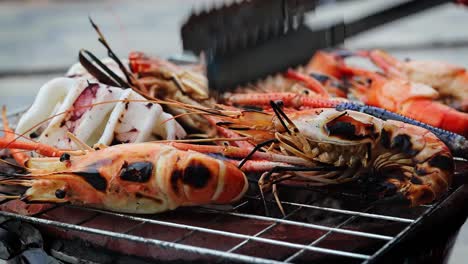 a side view of grilled shrimps that are being turned by a thai girl, thailand