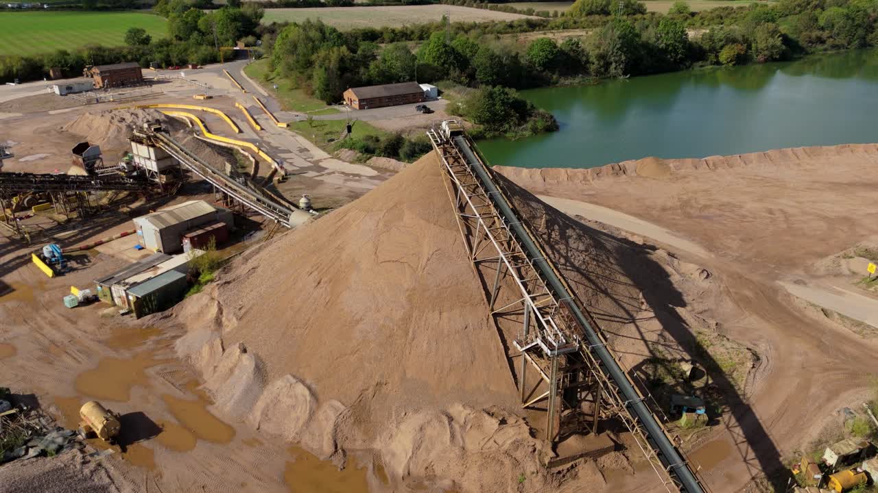 Drone footage of open quarry mining aggregates and asphalt materials with grading belts and plant equipment, Nottingham