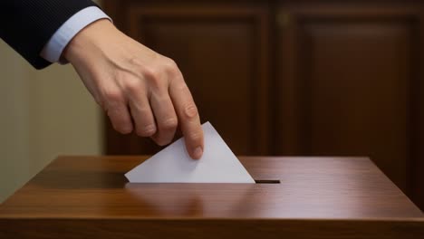casting votes: a hand in action for democracy during an election, dropping a ballot into a wooden box, emphasizing civic duty and participation in the electoral process