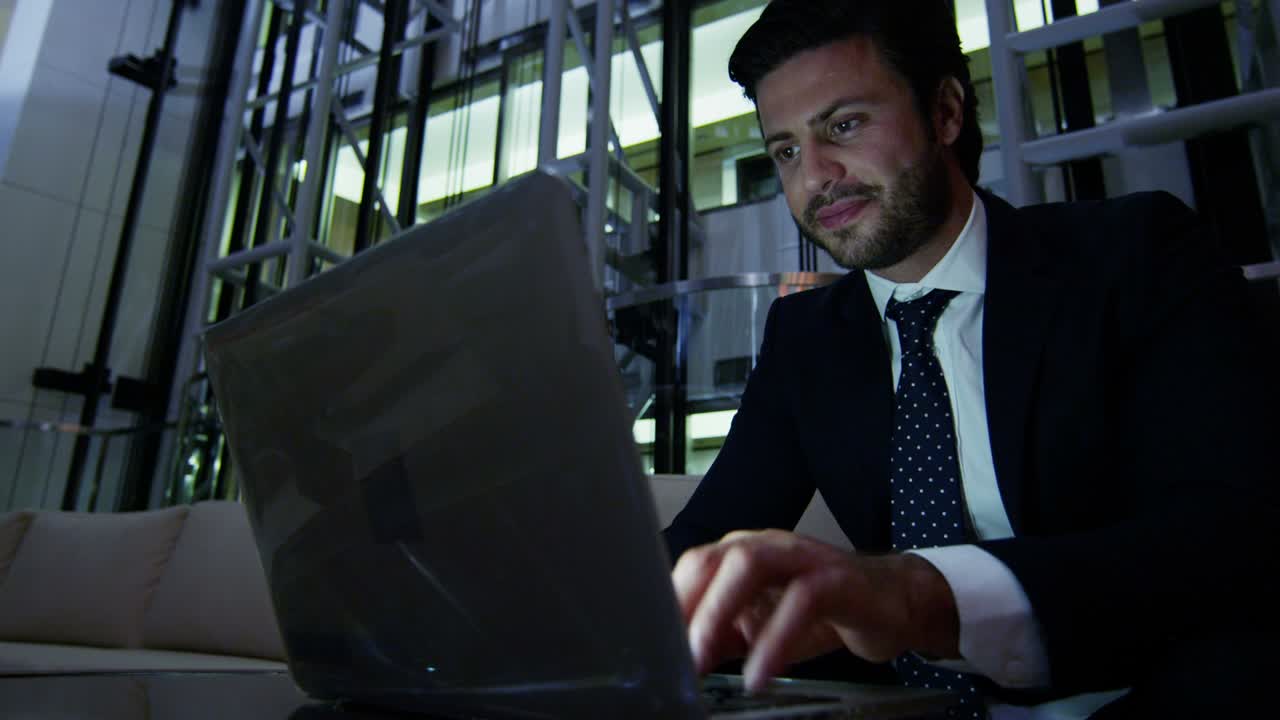 Arabic businessman hotel atrium night using laptop computer