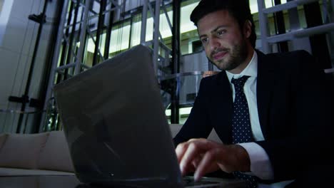 hombre de negocios árabe hotel atrium noche usando computadora portátil