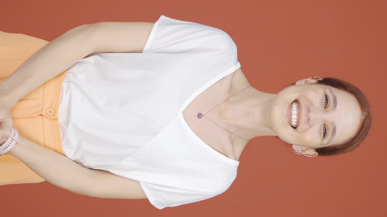 vídeo vertical de una mujer aplaudiendo emocionada a la cámara.