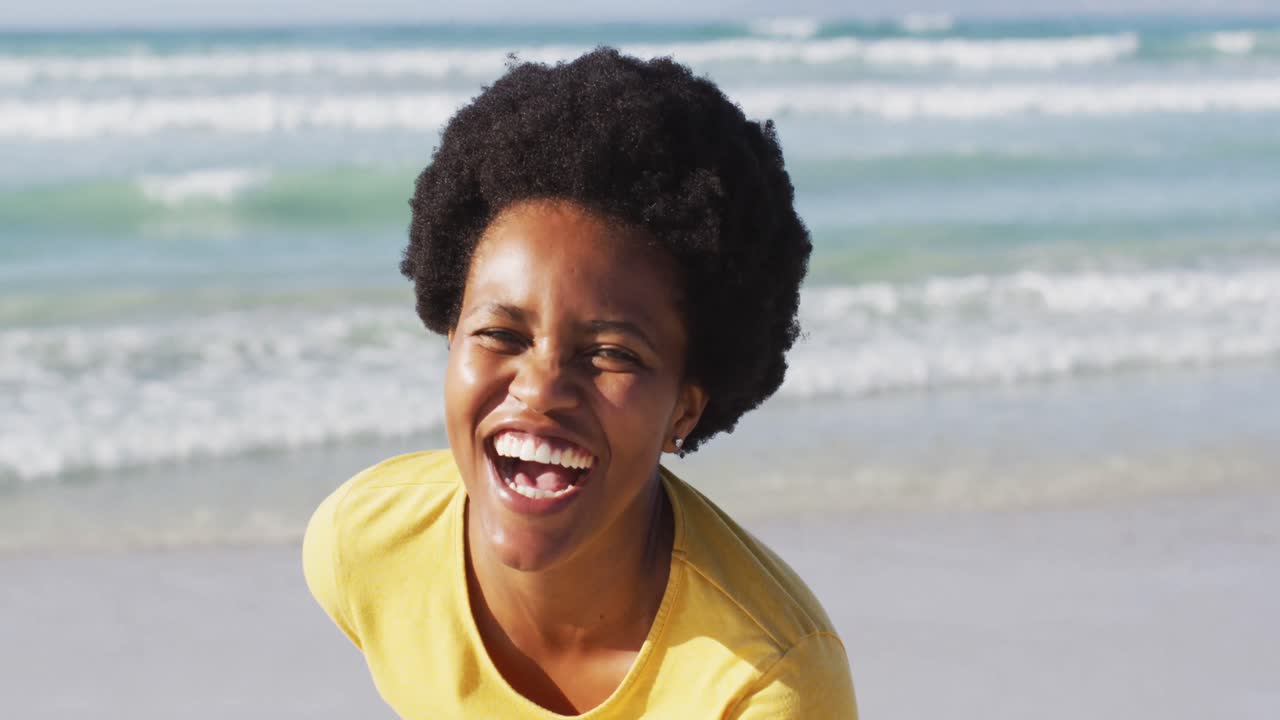 Portrait of happy african american woman on sunny beach