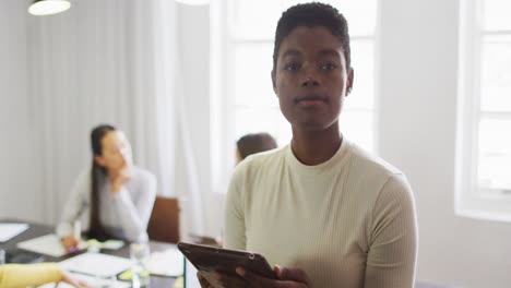 Glückliche-Afroamerikanische-Geschäftsfrau,-Die-Im-Büro-Steht-Und-In-Die-Kamera-Schaut