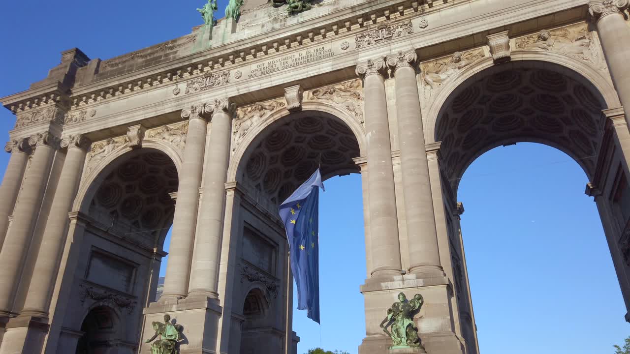European Union flag waving under Cinquantenaire arch in Brussels