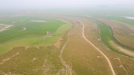 Vista-Aérea-De-Campos-En-Barbecho-Entre-Parcelas-Cultivadas-En-Día-De-Niebla