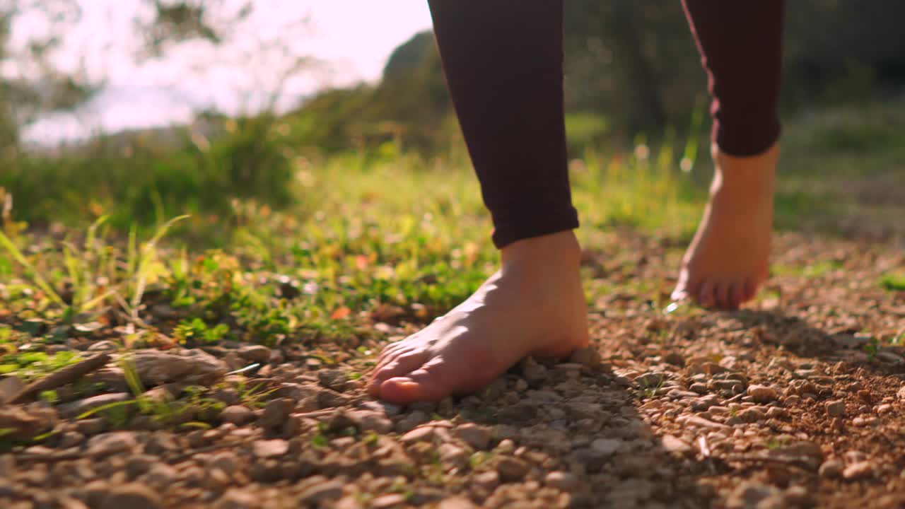 Gün doğumu sırasında ormanda çıplak ayakla yürüyen özgür genç kadın, huzurlu doğa yürüyüşü