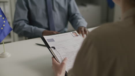 Black Male Applicant Answering Questions from Visa Officer at EU Embassy