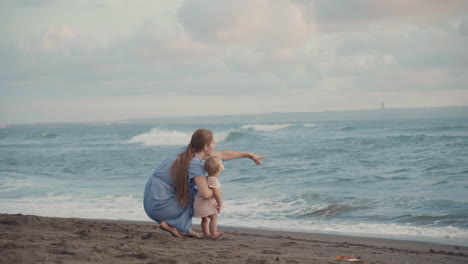 mother showing child ocean and sky