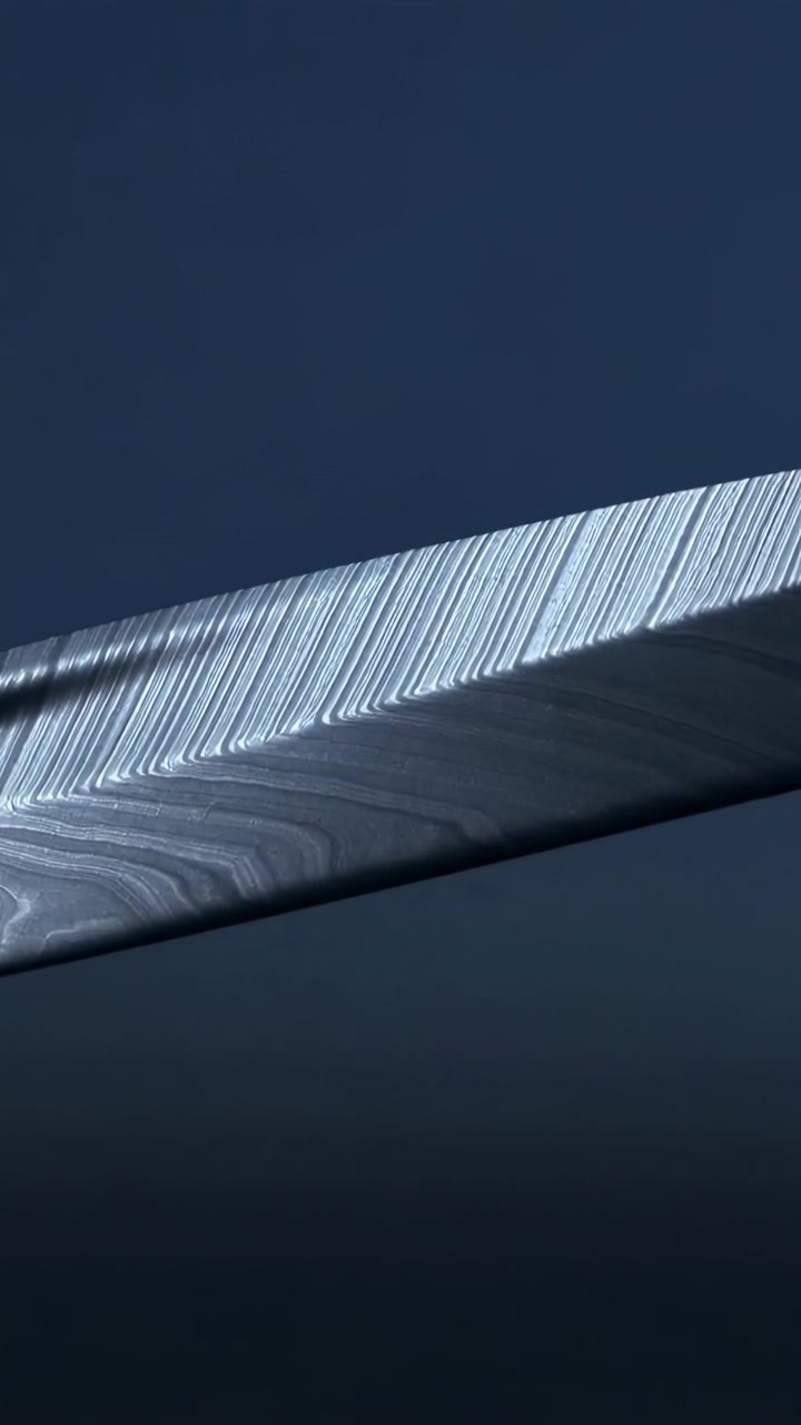 Vertikal video: Panorerende kamera afslører lang klinge i studie, lys viser årer og striber