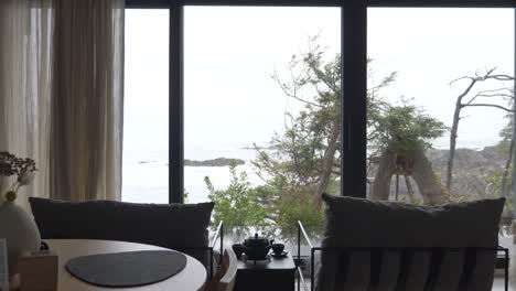 man opens window glass curtain to reveal scenic view from the room