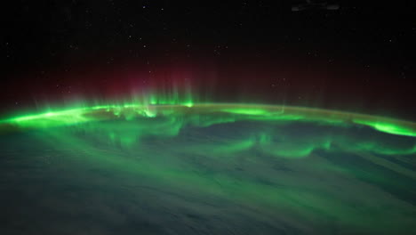 the international space station flies over the earth with aurora borealis visible 1