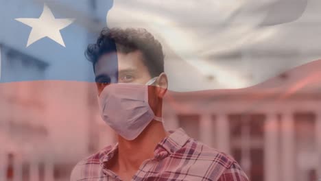 Animation-of-flag-of-chile-waving-over-latin-man-wearing-face-mask-in-city-street