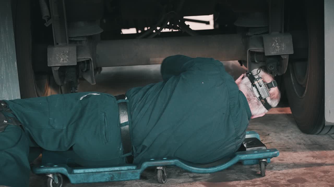 숙련된 자동차 정비사가 고객의 원활한 여행을 보장하기 위해 트레일러의 차대를 세심하게 서비스하고 있습니다.