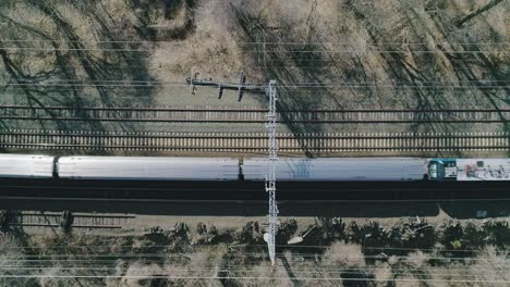 aerial static shot above tracks with train passing by