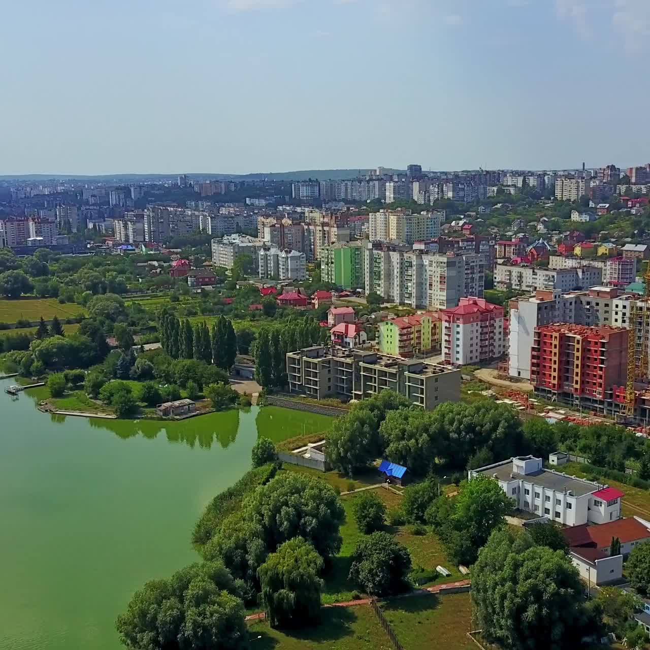 Beautiful city locating on the picturesque river bank. Blocks of flats and multi-storied buildings in the urban architecture. Top view