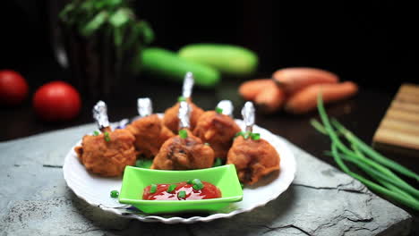 el hombre sirvió la piruleta de pollo crujiente frito al estilo del restaurante y la salsa de tomate en un plato