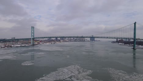 ambassador bridge connecting two countries over icy detroit river, aerial view