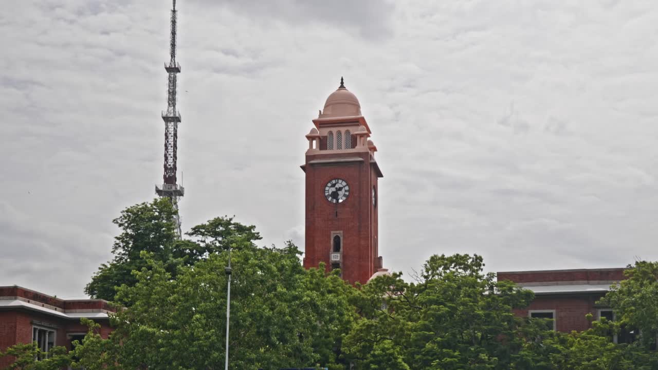Clock Tower with signal tower and trees at University of madras, Chennai, tamil nadu, india. day time, zoom out shot, 4k.